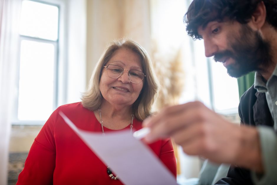 Starija žena i konzultant pregledavaju dokumente na sastanku