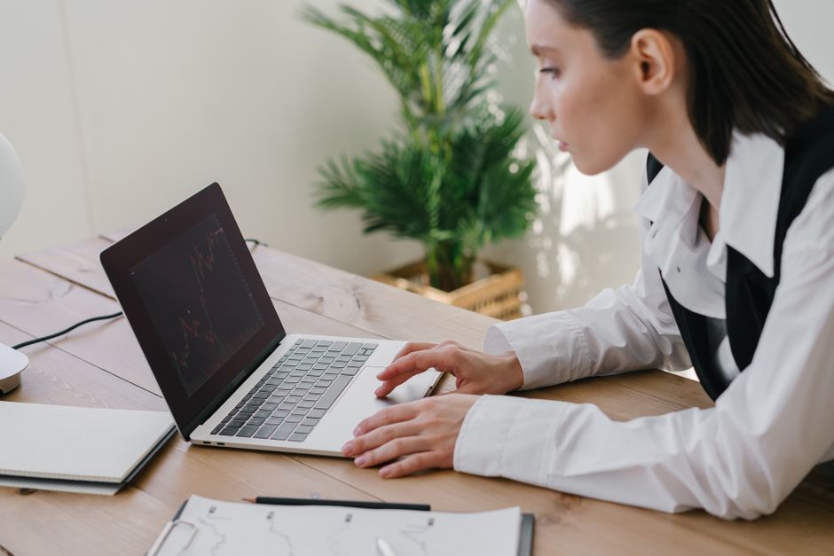 Konzultantica analizira financijske grafove na laptopu u uredu Bistro Savjeti